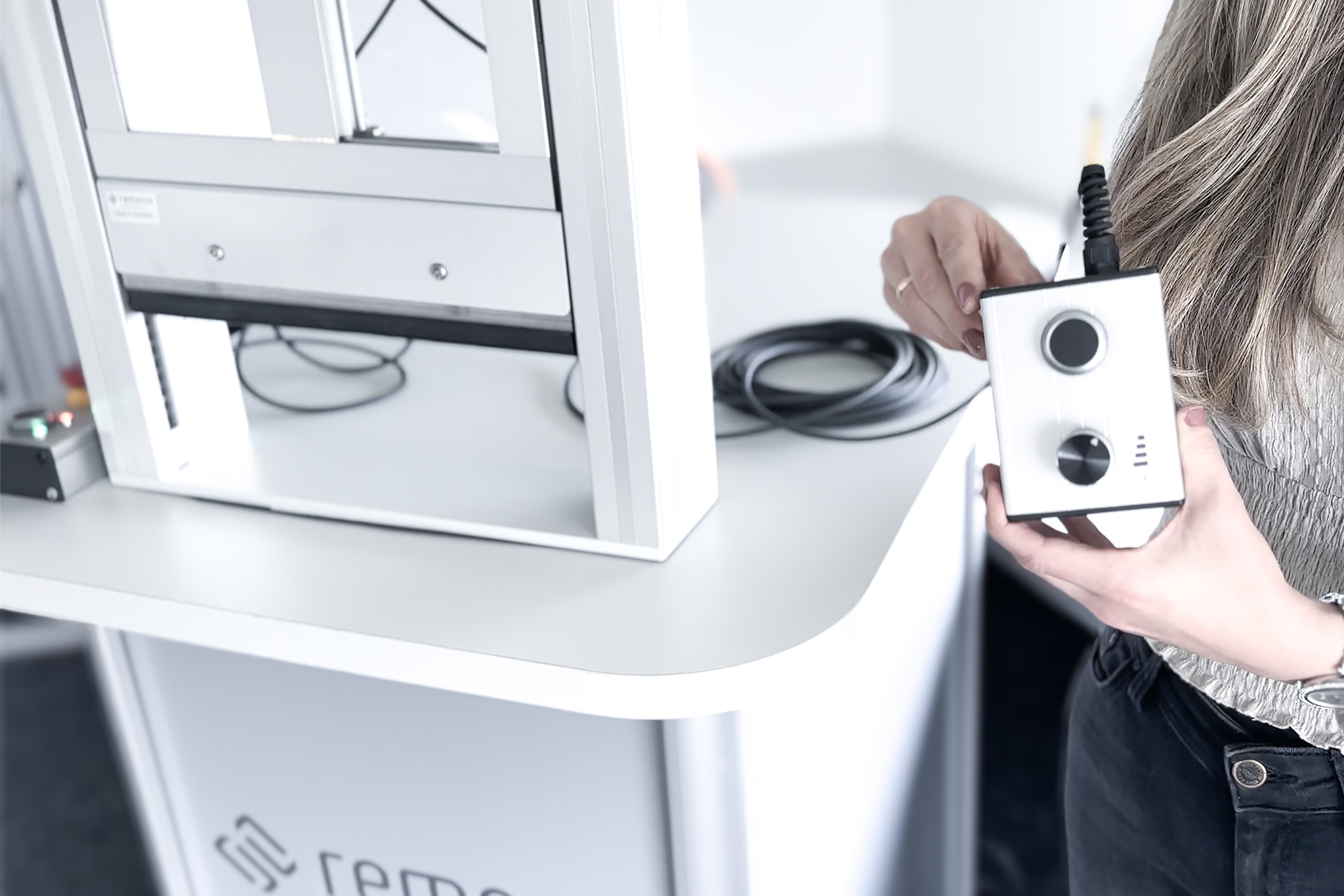 Mitarbeiterin führt den KI-gestützten Teach-Modus einer remonic® Hubtür mit integrierter Motorsteuereinheit durch